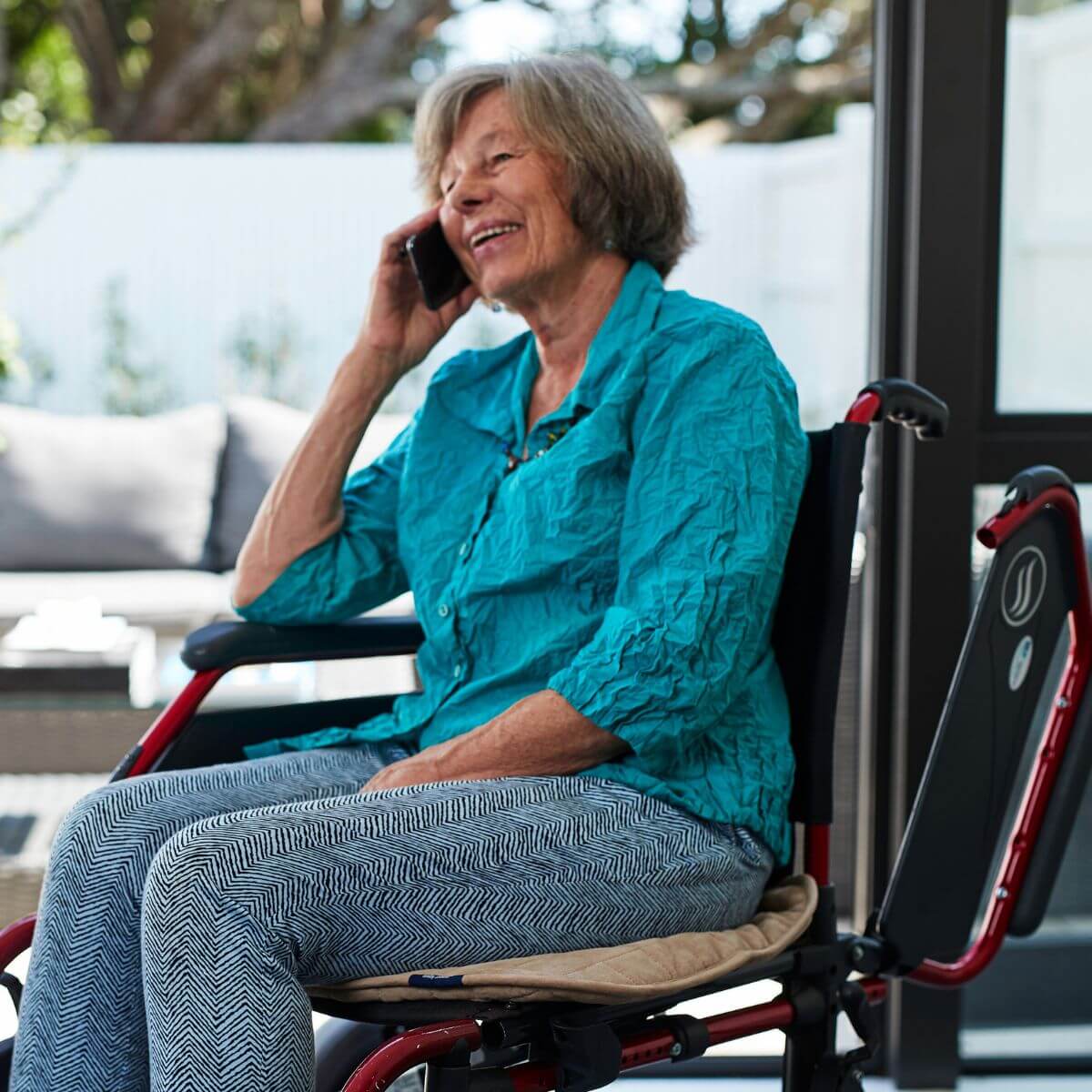 מגן מושב מבית ברולי בצבע מוקה בהיר, מונח על כסא גלגלים