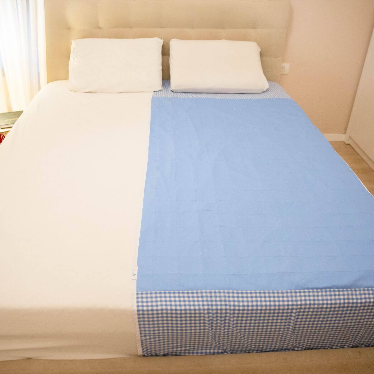 מגן מזרן סופג של ברולי פרוס לאורך המזרן, לשימוש גמיש והגנה ממוקדת על אזור השינה.