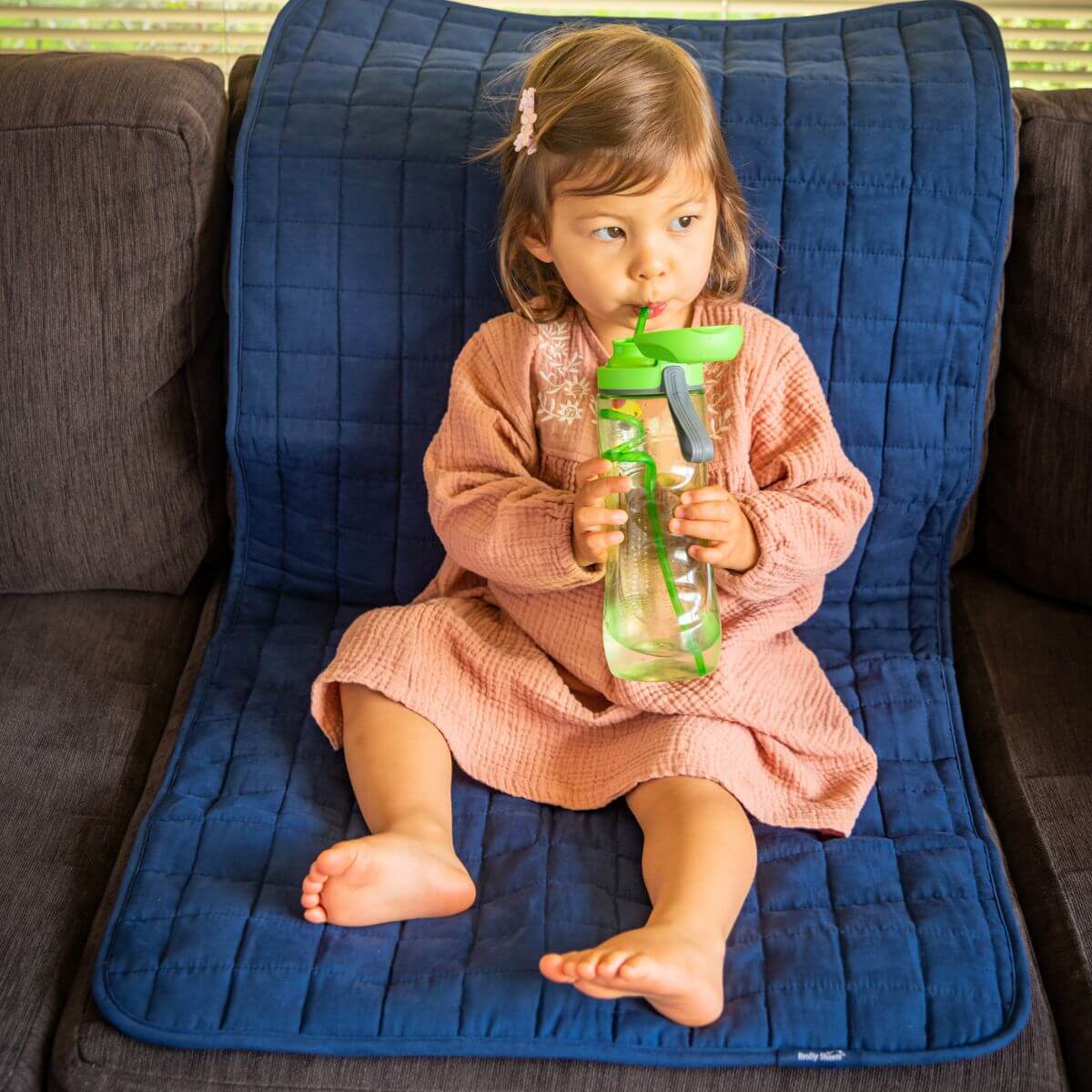 פעוטה יושבת על מגן מושב גדול של ברולי