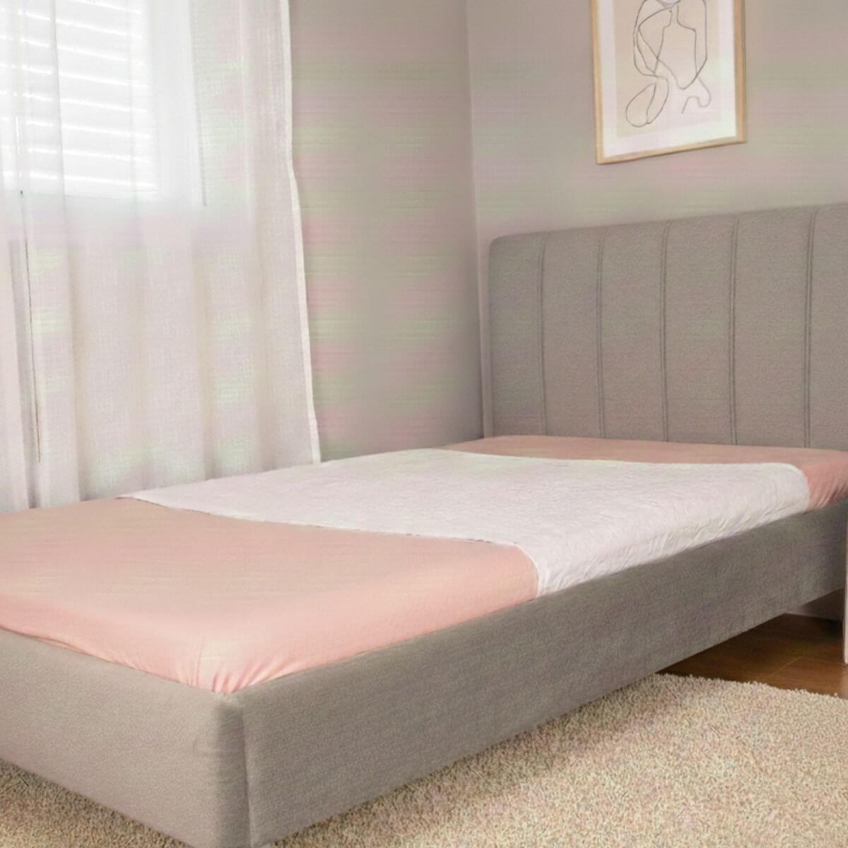 מגן מזרן סופג עם כנפיים מבית ברולי בצבע לבן, פרוס על מיטה וחצי